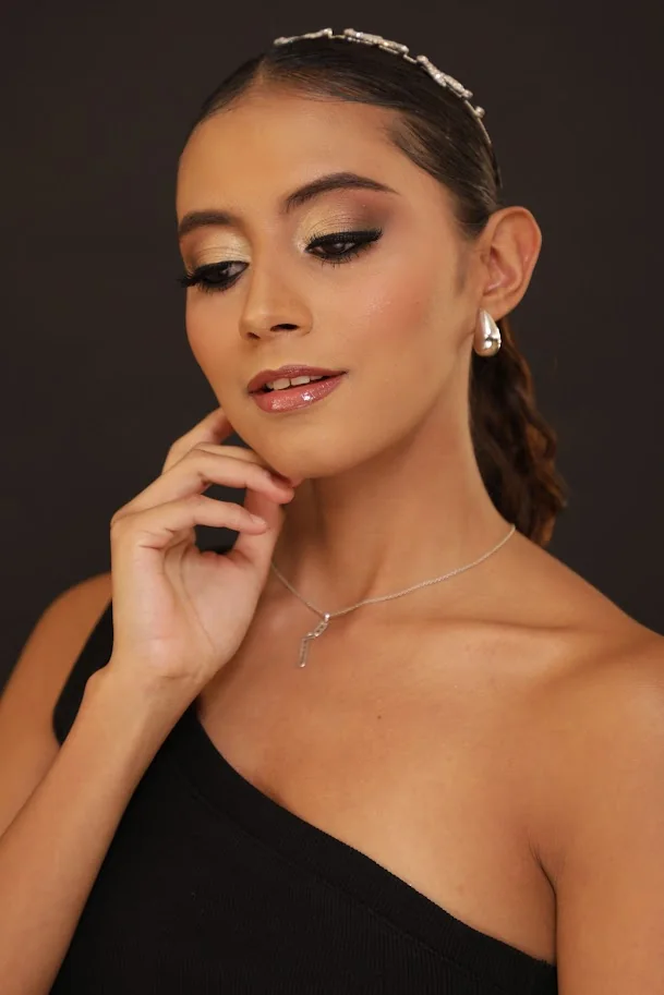 Look de belleza elegante con maquillaje dorado y peinado recogido